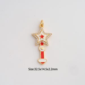 May include: Gold-colored star-shaped pendant with a red and white design. The star is encrusted with small, clear crystals. The pendant measures 1.28 inches long, 0.57 inches wide, and 0.09 inches thick. The pendant has a loop at the top for attaching to a chain.