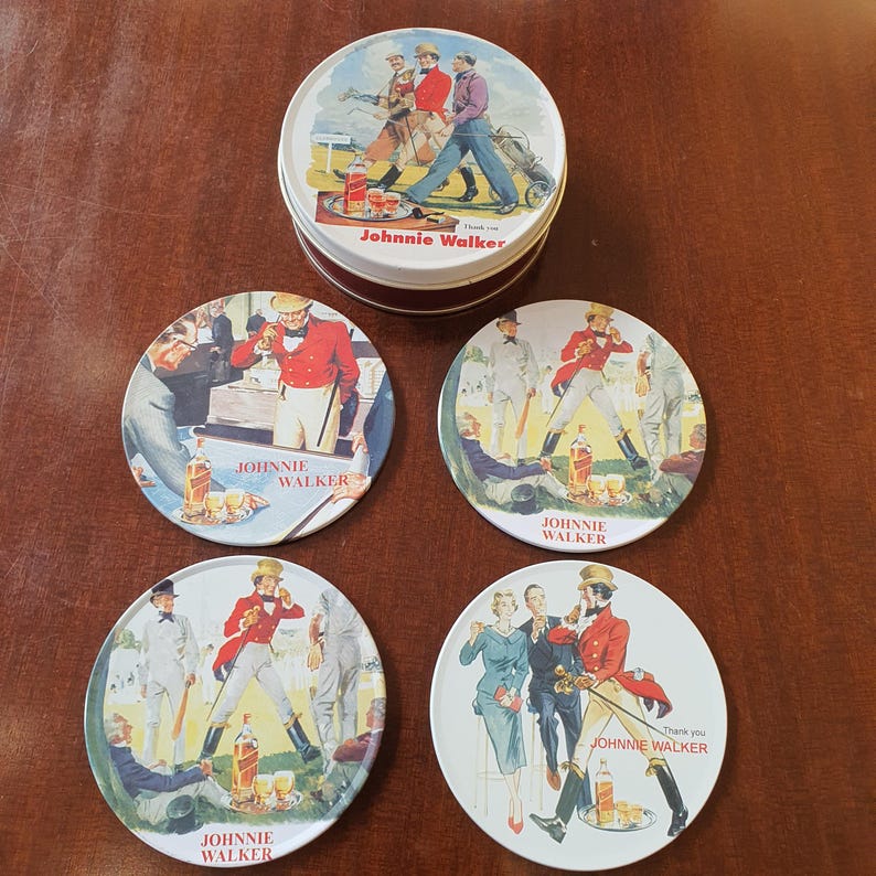 May include: A set of Johnnie Walker coasters and a matching tin. The coasters feature vintage illustrations of people in various settings, with the Johnnie Walker logo. The tin has a golf-themed illustration.