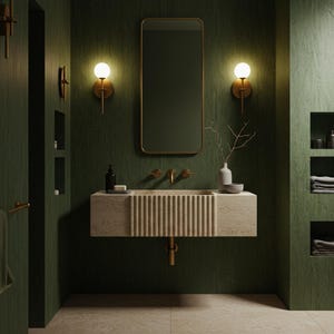 May include: A contemporary bathroom featuring a dark green wall and a beige stone sink with a ribbed design. Gold fixtures and a rectangular mirror with a gold frame are present. Two spherical wall sconces are positioned on either side of the mirror.