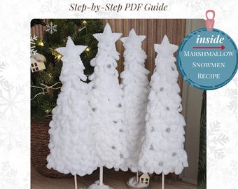 May include: Four handmade white Christmas trees with star toppers and silver accents. The trees are made of fluffy material and stand on wooden bases. The image includes text that reads "DIY Christmas Tree Tutorial" and "Step-by-Step PDF Guide."