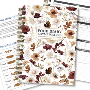 May include: A spiral-bound food diary and symptom log with a floral design. The cover features a white background with illustrations of flowers in shades of brown, burgundy, and cream. The title "FOOD DIARY & SYMPTOM LOG" is displayed prominently.
