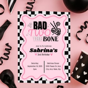 Könnte beinhalten: Eine rosa Geburtstagseinladung mit dem Text "BAD TWO THE BONE" und "Sabrinas 2. Geburtstag". Die Einladung hat einen schwarz-weißen Schachbrettmuster-Rand und dekorative Elemente wie einen Totenkopf, eine Skeletthand und Blumen. Enthält Datum, Uhrzeit und Adresse.