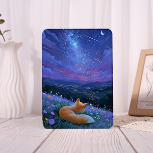 May include: A rectangular tablet case featuring a vibrant illustration of a fox resting in a field of purple and orange flowers. The scene depicts a night sky filled with a bright galaxy, shooting stars, and a crescent moon over a distant valley.