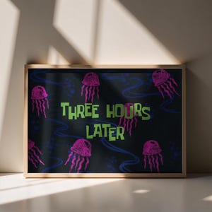 Peut inclure: Impression d'art encadrée avec un fond noir, des méduses roses et des lignes ondulées bleues. Le texte "THREE HOURS LATER" est en vert. L'impression est dans un cadre en bois brun clair.
