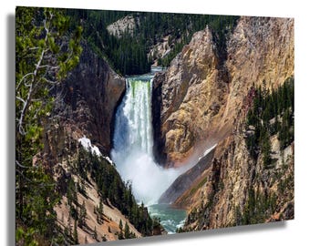 May include: A scenic canvas print of a waterfall cascading down a rocky canyon. The water is white and foamy, contrasting with the brown and tan canyon walls. Green trees line the canyon rim, and the water flows into a turquoise pool below.