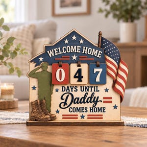 May include: A wooden countdown sign featuring a soldier silhouette, a pair of boots, and a miniature American flag. The sign displays the text "WELCOME HOME" and "DAYS UNTIL Daddy COMES HOME" with three rotating number blocks currently set to 047.