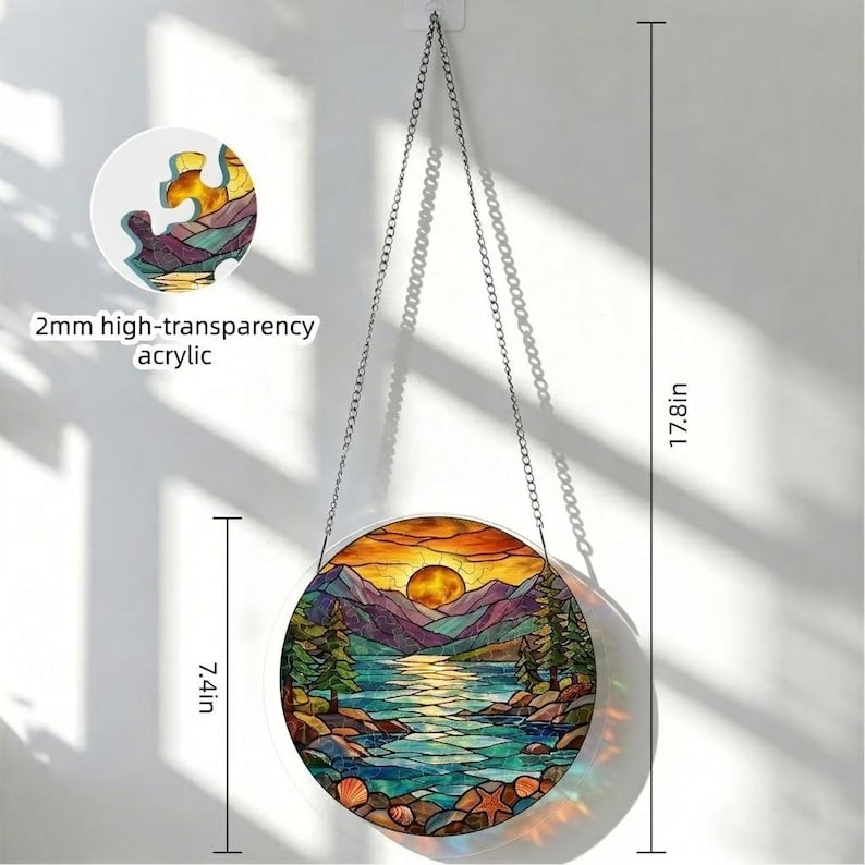 May include: A circular stained-glass window showing a sunset over a lake and mountains. The window is 18.8 cm in diameter and 45.2 cm long, suspended by a chain. The text "2mm high-transparency acrylic" is visible. The artwork features vibrant colours.