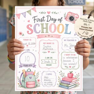 May include: A First Day of School sign featuring pastel watercolour illustrations of a backpack, books, and a camera. The sign includes fillable sections for name, age, teacher, grade, and interests, with text reading First Day of School and 8x10 Inch Size.