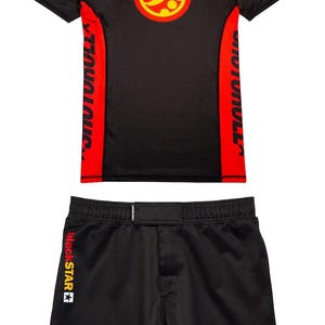 Könnte beinhalten: Schwarzes Sport-Set, bestehend aus T-Shirt und Shorts. Das T-Shirt hat ein rotes und gelbes kreisförmiges Logo und rote Seitenteile mit weißem Text. Die Shorts haben gelbe Akzente und ein passendes Logo.