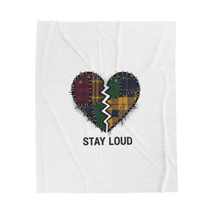 Peut inclure: Couverture blanche avec un motif de cœur brisé. Le cœur est divisé en deux, chaque moitié présentant un motif écossais différent dans les tons de rouge, vert et jaune. Le texte "STAY LOUD" est imprimé en dessous.