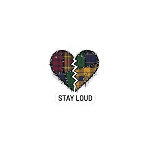 May include: A sticker featuring a broken heart design. The heart is composed of patchwork in various plaid patterns, including red, green, and yellow. The words "STAY LOUD" are printed in black on a white rectangle below the heart.