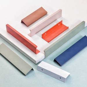 以下が含まれることがあります： コーラル、ピンク、オレンジ、グレー、ブルー、ホワイトなど、さまざまな色合いのカラフルなキャビネットプルコレクション。これらのモダンでミニマリストなハンドルは金属製で、引き出しやキャビネットに簡単に取り付けられるように設計されています。