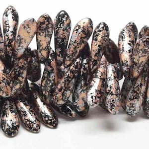 May include: Close-up of a strand of teardrop-shaped beads. The beads have a speckled pattern of black, copper, and silver. The beads are strung together, creating a textured design. The background is white.