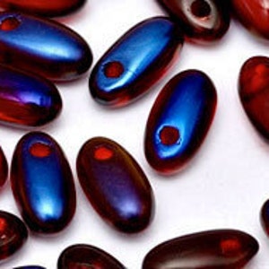 May include: A collection of small, oval-shaped glass beads with an iridescent finish. The beads are a mix of deep red and blue colours.