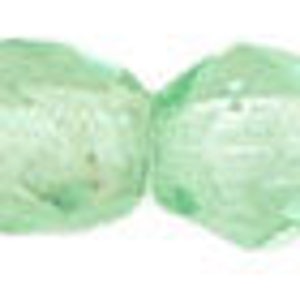 May include: A strand of light green glass beads. The beads are faceted and have a slightly irregular shape.