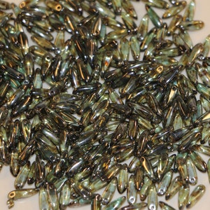 May include: A large pile of iridescent green glass beads in a teardrop shape. The beads have a metallic sheen and are perfect for jewelry making.