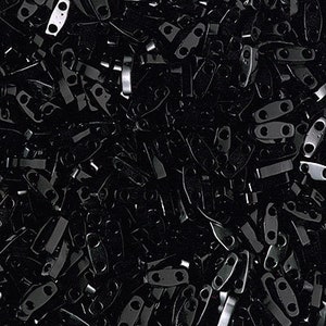 May include: A large pile of black metal clasps or buckles. The clasps are all the same size and shape, and they are arranged in a random pattern.
