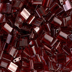 May include: A close-up image of a pile of small, dark red glass beads. The beads are square shaped with a hole in the center.