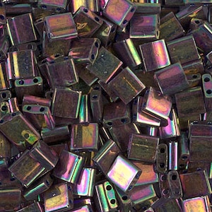 Könnte beinhalten: Nahaufnahme einer Ansammlung von irisierenden, dunkelbraunen quadratischen Perlen mit zwei Löchern. Die Perlen haben einen metallischen Glanz und sind perfekt für die Schmuckherstellung.