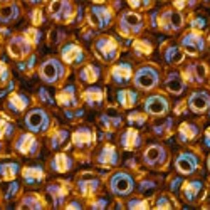 May include: A close-up image of a large quantity of small, round, iridescent gold beads. The beads have a metallic sheen and are perfect for jewelry making or crafting.