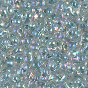 Puede incluir: Primer plano de un montón de cuentas de vidrio iridiscentes. Las cuentas son transparentes con un efecto brillante de arcoíris. Cada cuenta tiene una forma redondeada con un agujero para ensartar. Adecuadas para la fabricación de joyas y manualidades.