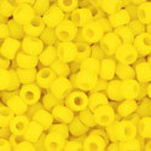 May include: A close-up image of a large quantity of small, bright yellow plastic beads. The beads are round with a hole in the center.