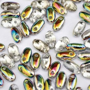 May include: A collection of iridescent oval-shaped beads with a hole for stringing. The beads have a clear, silver, and rainbow-colored finish. These beads are suitable for jewelry making and craft projects.