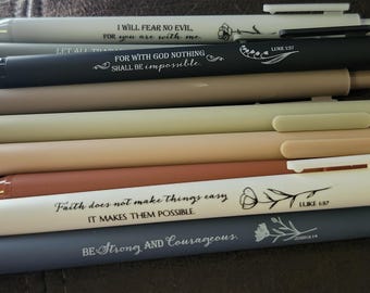 May include: An assortment of pens in various colors, including white, black, and shades of brown and gray. Each pen has an inspirational quote printed on it, such as "I will fear no evil" and "Be Strong and Courageous."