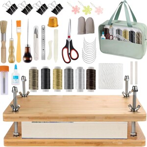 May include: A bookbinding kit featuring a bamboo press with metal hardware, a light green storage bag, six spools of thread, scissors, a gold thimble, needles, clips, brushes, awls, a metal ruler, and various tools for crafting and repairing books.