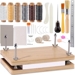 May include: A bookbinding kit featuring a wooden press with four metal threaded rods and wing nuts, six spools of colored thread, two brushes, an awl, needles, bone folders, two rolls of tape, grey boards, and a 20-centimeter metal ruler.