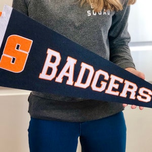 May include: A blue felt pennant with a white felt "BADGERS" and an orange felt "S".