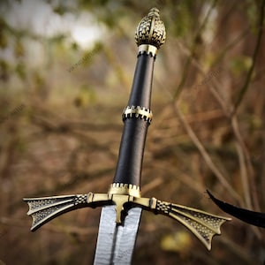 May include: A sword featuring a black leather-wrapped grip, a brass pommel with a textured geometric pattern, and a matching brass crossguard with flared, dotted ends. The blade displays a visible Damascus steel pattern with a central fuller.