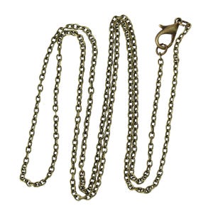 May include: An antique brass-colored chain necklace with a lobster clasp. The chain is made of small, oval-shaped links. The necklace is displayed against a white background.