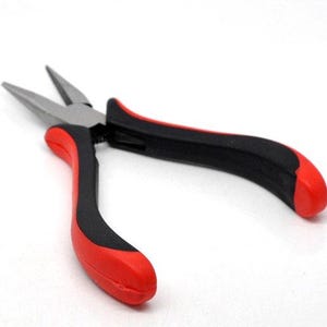 May include: Needle-nose pliers with a silver metal head and red and black handles. The pliers are designed for precision work and feature a pointed tip for gripping small objects. The handles are ergonomically designed for comfort and control.