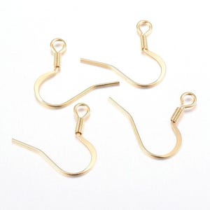 May include: Four gold-toned earring hooks with a coiled wire detail at the top. The hooks are designed to be used with jewelry making supplies.