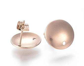 May include: A pair of rose gold earring posts with a round, smooth, flat top. The posts are made of metal and have a hole in the center of the top.