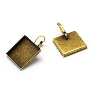 May include: A pair of antique brass square earring blanks with a hook closure.