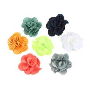 May include: Assortment of eight fabric flower embellishments in various colors, including orange, green, blue, gray, and white. The flowers are all approximately the same size and have a similar ruffled design.