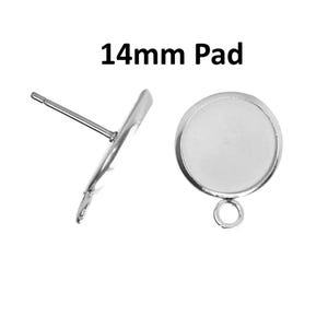 May include: Two silver-toned metal earring studs with a 14mm pad. One stud is shown from the side with a post, and the other is shown from the front with a circular flat tray and a small loop at the bottom for attaching additional jewelry components.