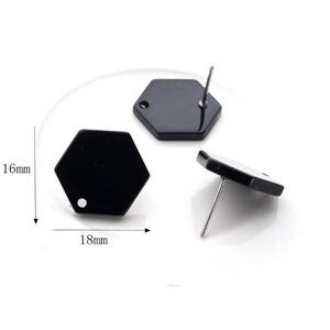 May include: Two black hexagonal earring studs with silver posts. The earrings measure 18 mm wide and 16 mm high.