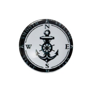 Peut inclure: Bouton rond à thème nautique avec un fond blanc et un motif d'ancre noir. Le bouton porte l'inscription "SMOOTH SAILING SINCE M 1980" sur le bord, avec les points cardinaux (N, E, S, W) autour de l'ancre.