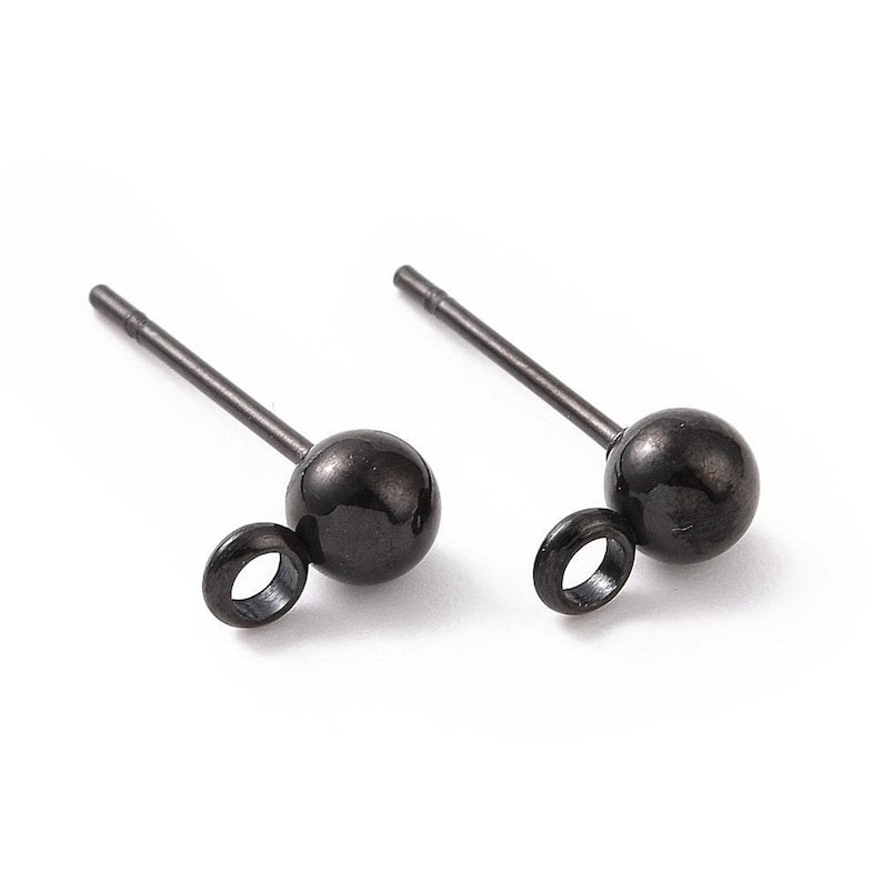 May include: A pair of black stud earrings with a small loop on the side. The earrings are made of metal and have a smooth, polished finish.