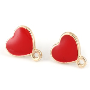May include: Two gold-colored heart-shaped charms with red enamel. Each charm has a small loop for attaching to jewelry or other crafts.