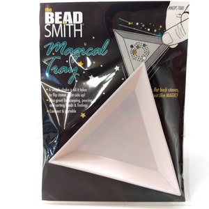May include: A white triangular bead tray with the text "Magical Tray" and "the Bead Smith" on the packaging. The tray is designed to flip flat-back stones right-side up with a simple shake.