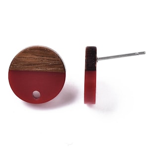 May include: A pair of round wooden earrings with a red and brown colour scheme. The earrings are made of wood and resin and have a simple, modern design.