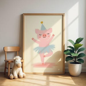 Puede incluir: Impresión enmarcada que presenta una ilustración de un cerdo rosa con tutú azul y gorro de fiesta, bailando. La obra de arte está enmarcada en un marco de madera. Una pequeña silla de madera y un peluche están en primer plano. La imagen tiene un fondo claro.