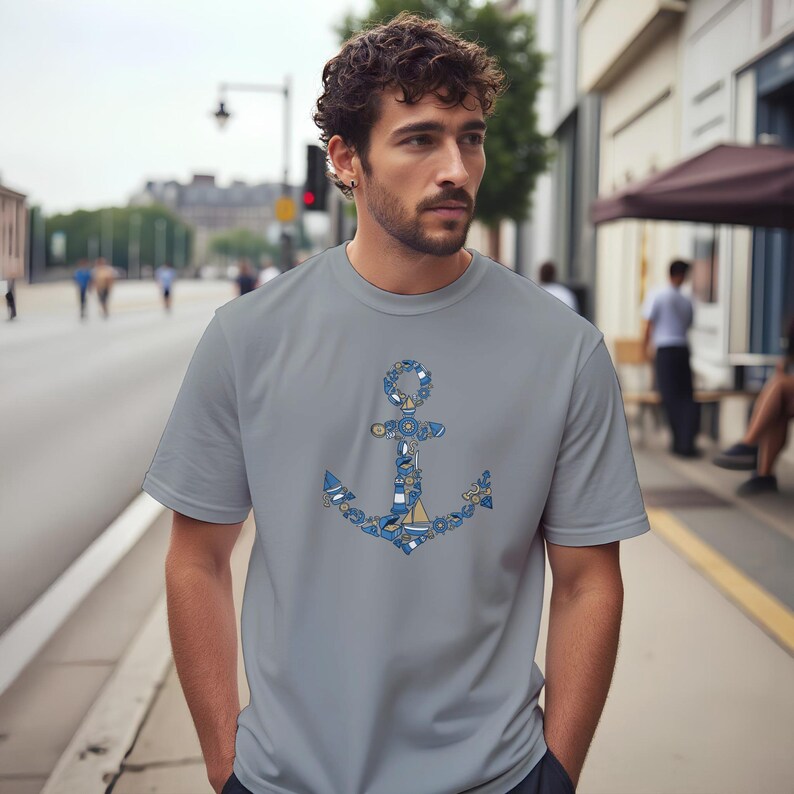 Puede incluir: Una camiseta gris con un dise&ntilde;o de ancla detallado. El ancla est&aacute; compuesta por varios elementos n&aacute;uticos en tonos azules y blancos. La camiseta es una prenda casual para el d&iacute;a a d&iacute;a.