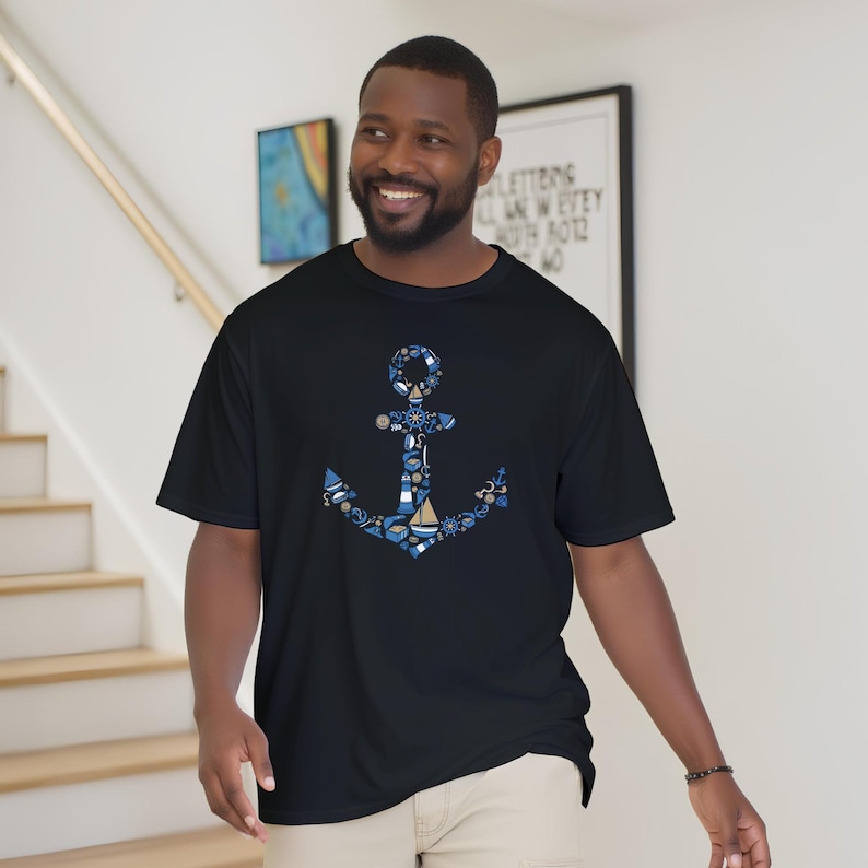 Puede incluir: Camiseta negra con un dise&ntilde;o de ancla azul compuesto por elementos n&aacute;uticos como barcos y timones. El ancla est&aacute; centrada en la camiseta, con un patr&oacute;n detallado. La camiseta es de manga corta y parece estar hecha de un material suave.