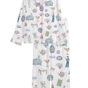 May include: A white long-sleeve pajama set with a button-down top and matching pants. The fabric features a colorful repeating print of teapots, cocktails, floral arrangements, decorative vases, small tables, and figures lounging on sofas.