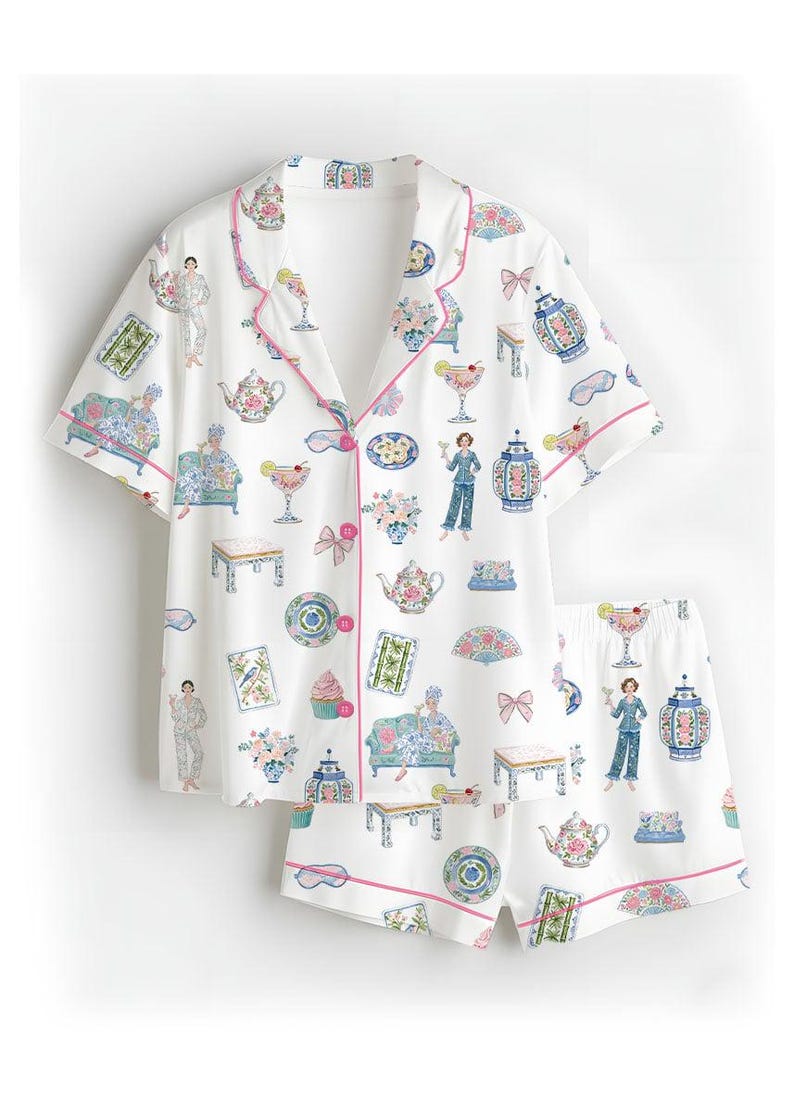 May include: A white short-sleeve pajama set with pink piping, featuring a repeating print of teapots, cocktails, decorative vases, small tables, cupcakes, fans, bows, and figures lounging on sofas, all rendered in soft pastel colors across the fabric.